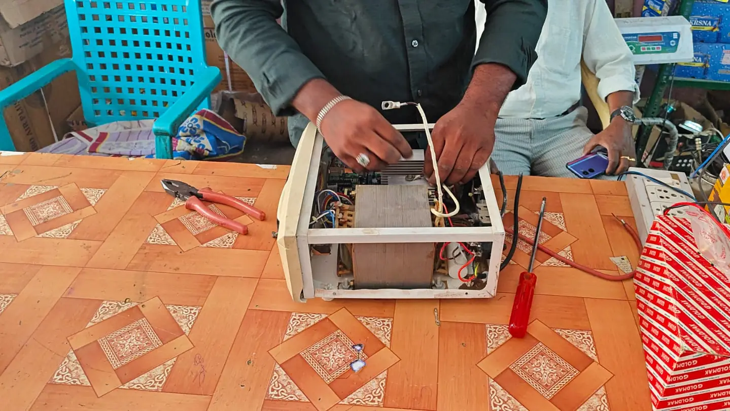 Hands repairing a power unit at a workbench